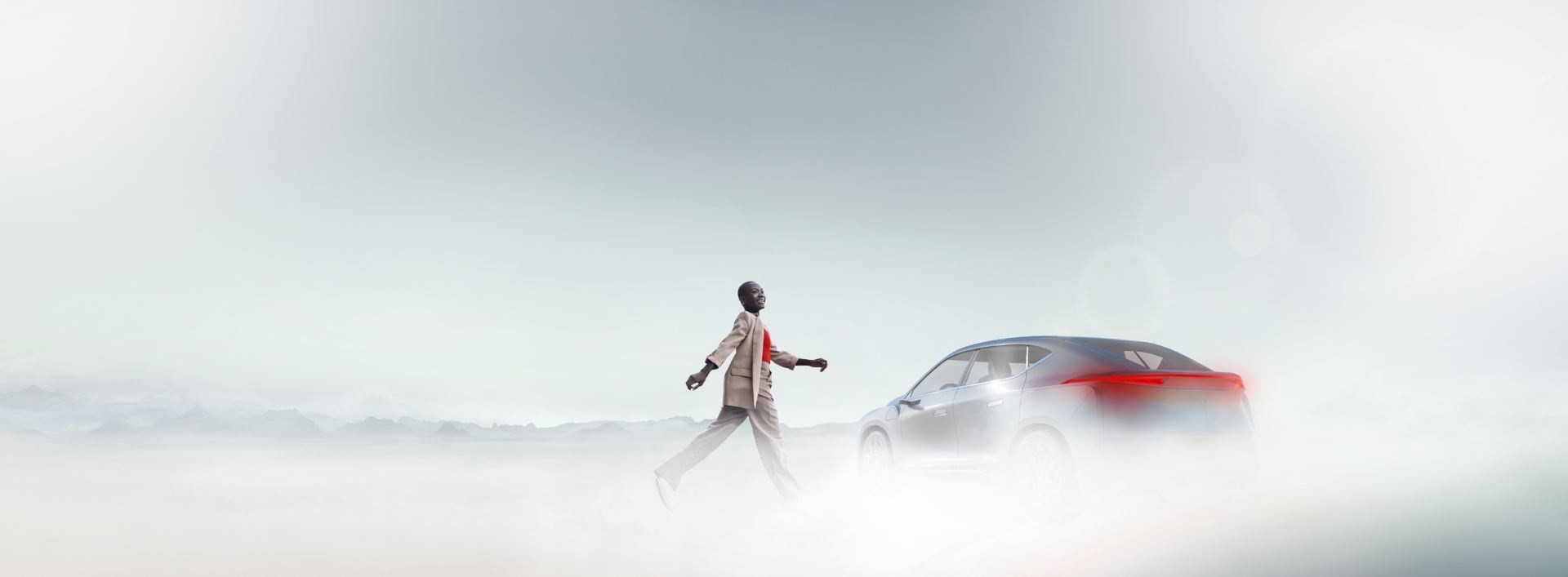 Person walking toward a sleek car in a misty landscape