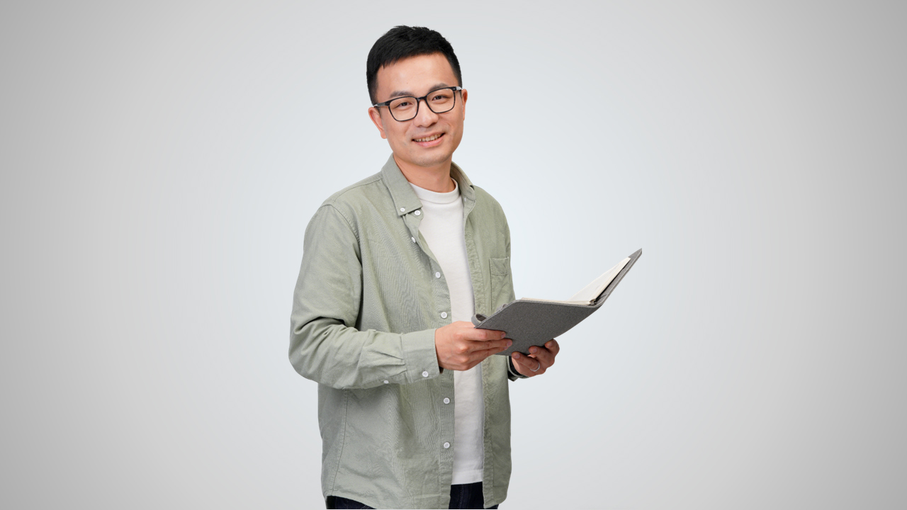 Person standing holding an tablet and smiling