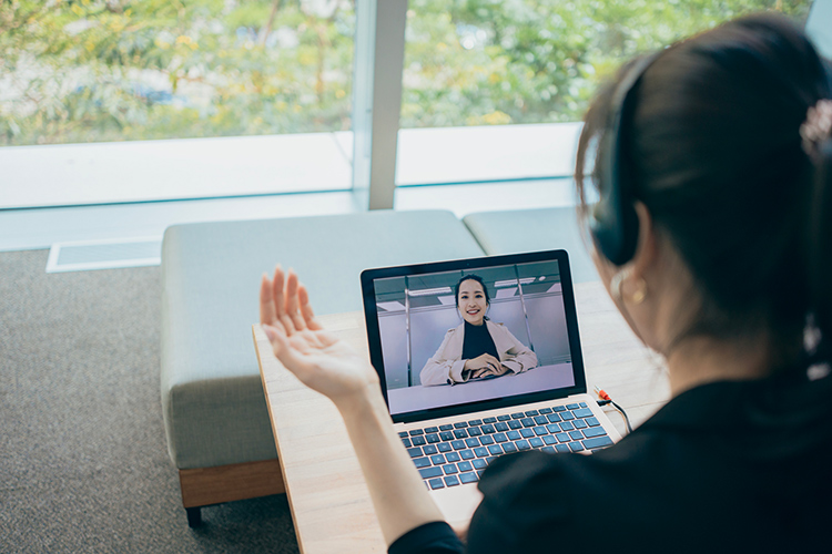 A person talking with someone on a laptop in an office environment