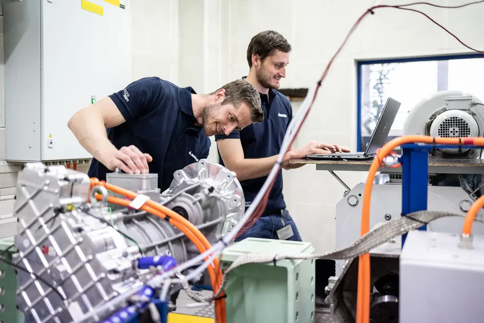 Two engineers testing electric motor equipment in a lab