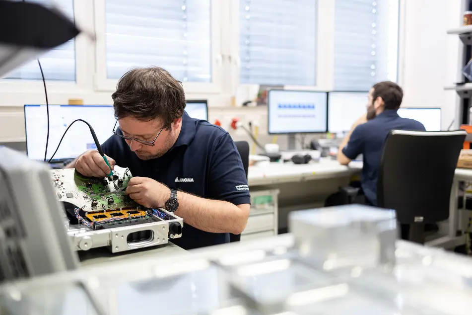 Engineer soldering components on a circuit board at a workstation