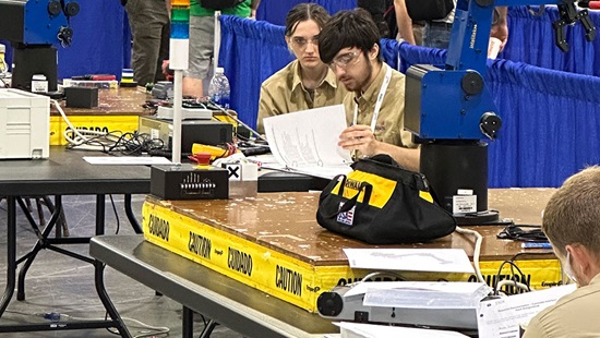 Andrew  Avielle during their competition working on their robot