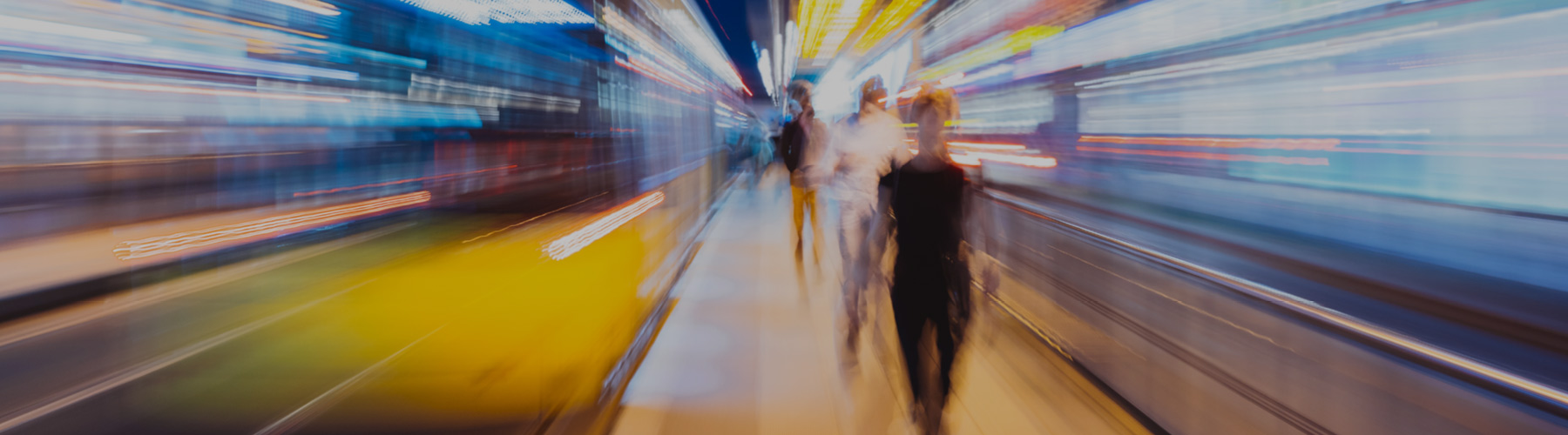 Blurred people walking down a subway platform