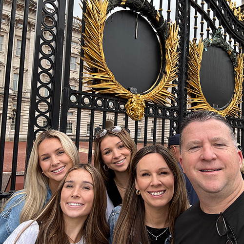 Paul Blackburn and his family standing in front of Buckingham Palace