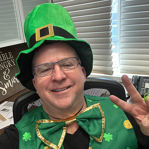 Paul Blackburn wearing a green top hat, bow tie and vest for St. Patrick's Day
